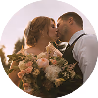 Brooke and Derick kissing behind a blush and cream bouquet at their Montana wedding