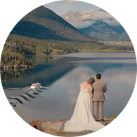 Brooke and Matthew in wedding attire looking out over a mountain lake in Montana